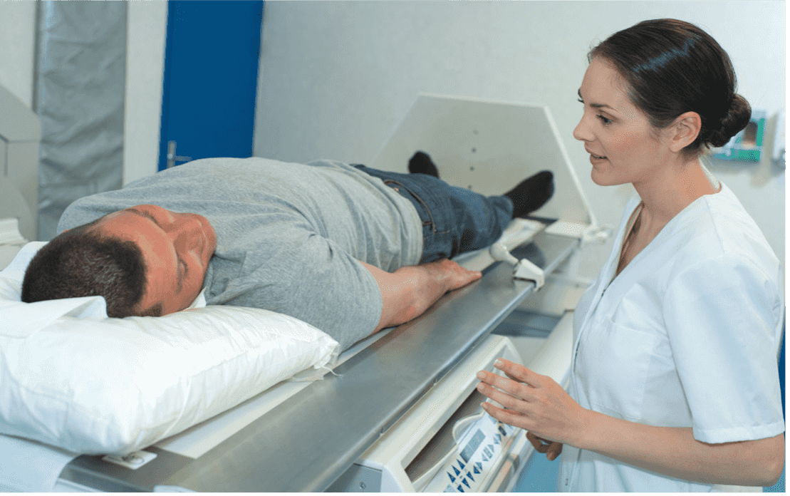 nurse talking to male patient in radiation machine 