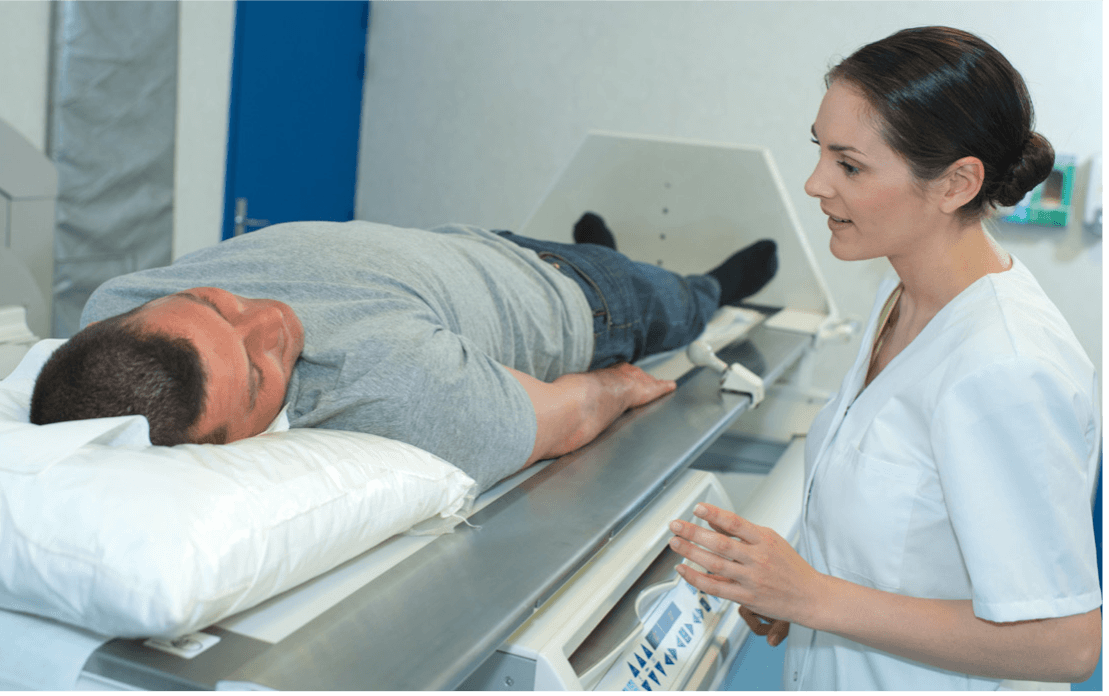 nurse talking to male patient in radiation machine 